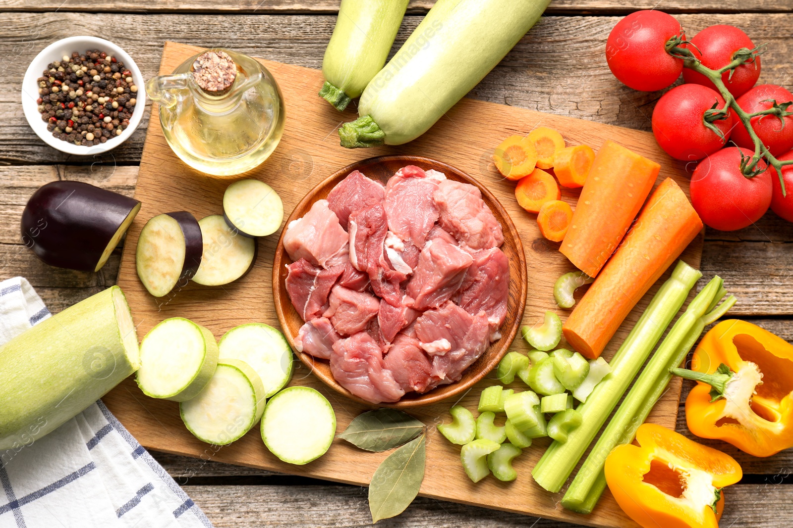 Photo of Cooking stew. Uncooked meat and vegetables on wooden table, top view