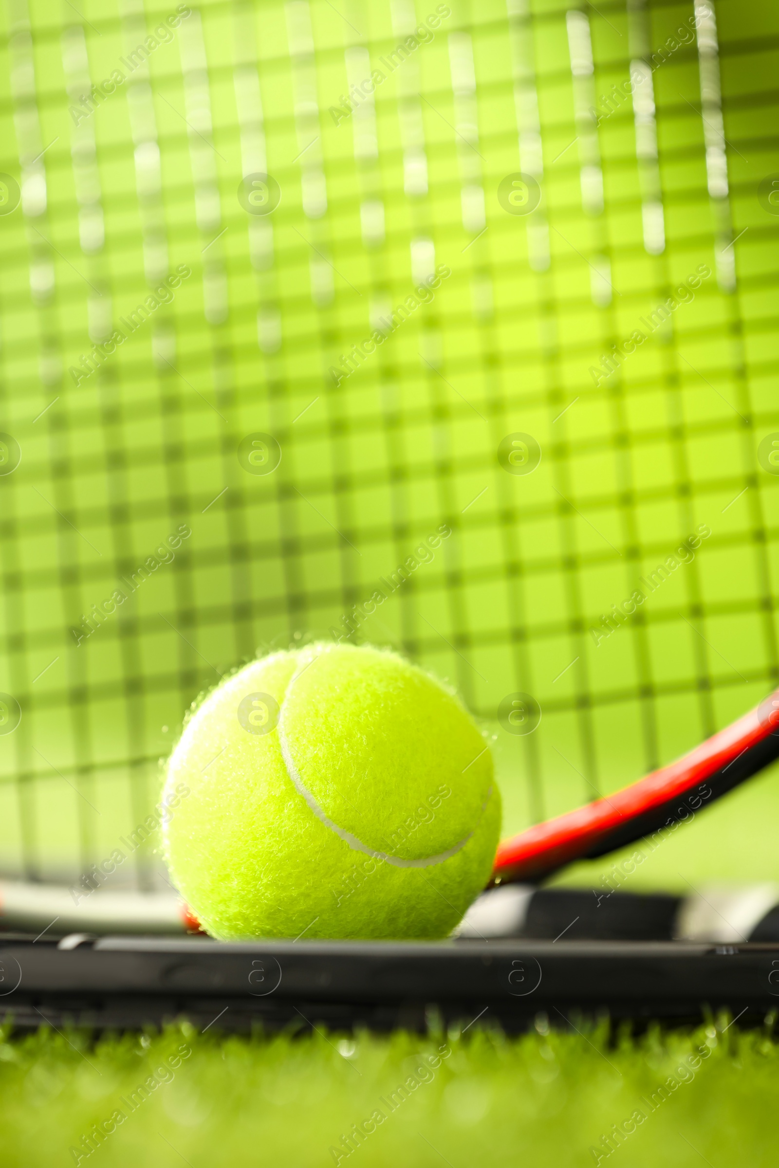 Photo of Tennis rackets and ball on green artificial grass, closeup