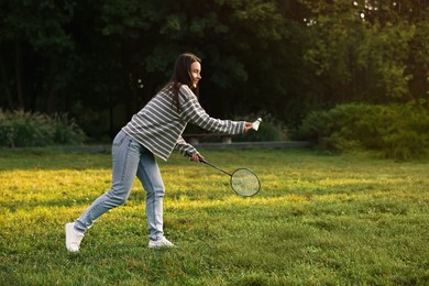 Photo of Young woman playing badminton racket in park