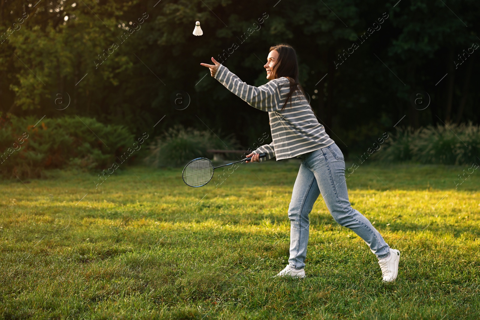 Photo of Young woman playing badminton racket in park