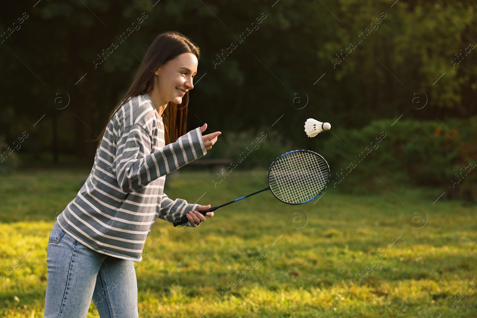 Photo of Young woman playing badminton racket in park