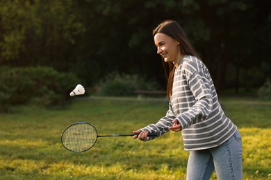 Photo of Young woman playing badminton racket in park