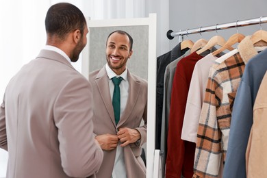 Smiling man dressing near mirror at home