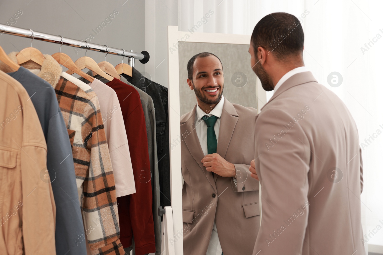 Photo of Smiling man looking at mirror at home