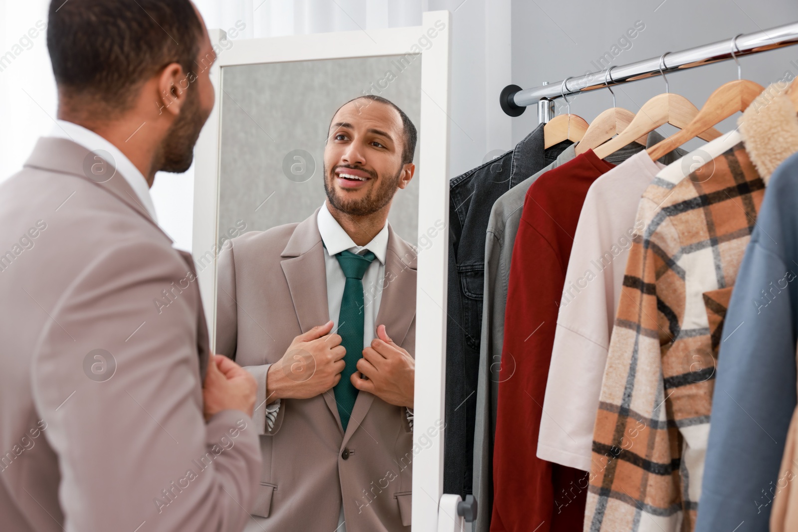 Photo of Smiling man looking at mirror at home