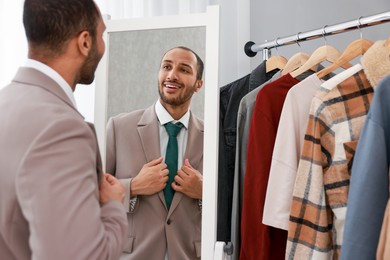 Photo of Smiling man looking at mirror at home