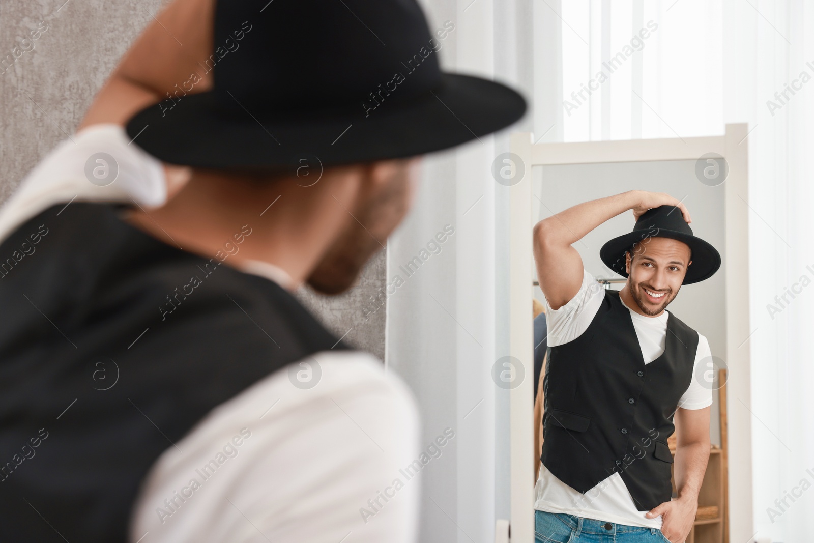 Photo of Smiling man looking at mirror at home