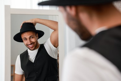 Photo of Smiling man looking at mirror at home