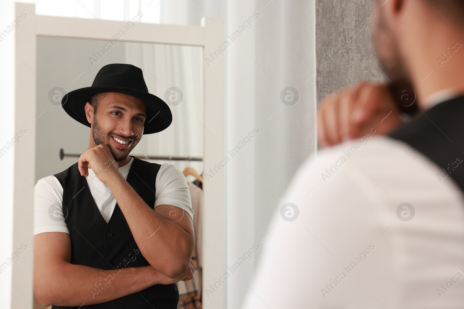 Photo of Smiling man looking at mirror at home