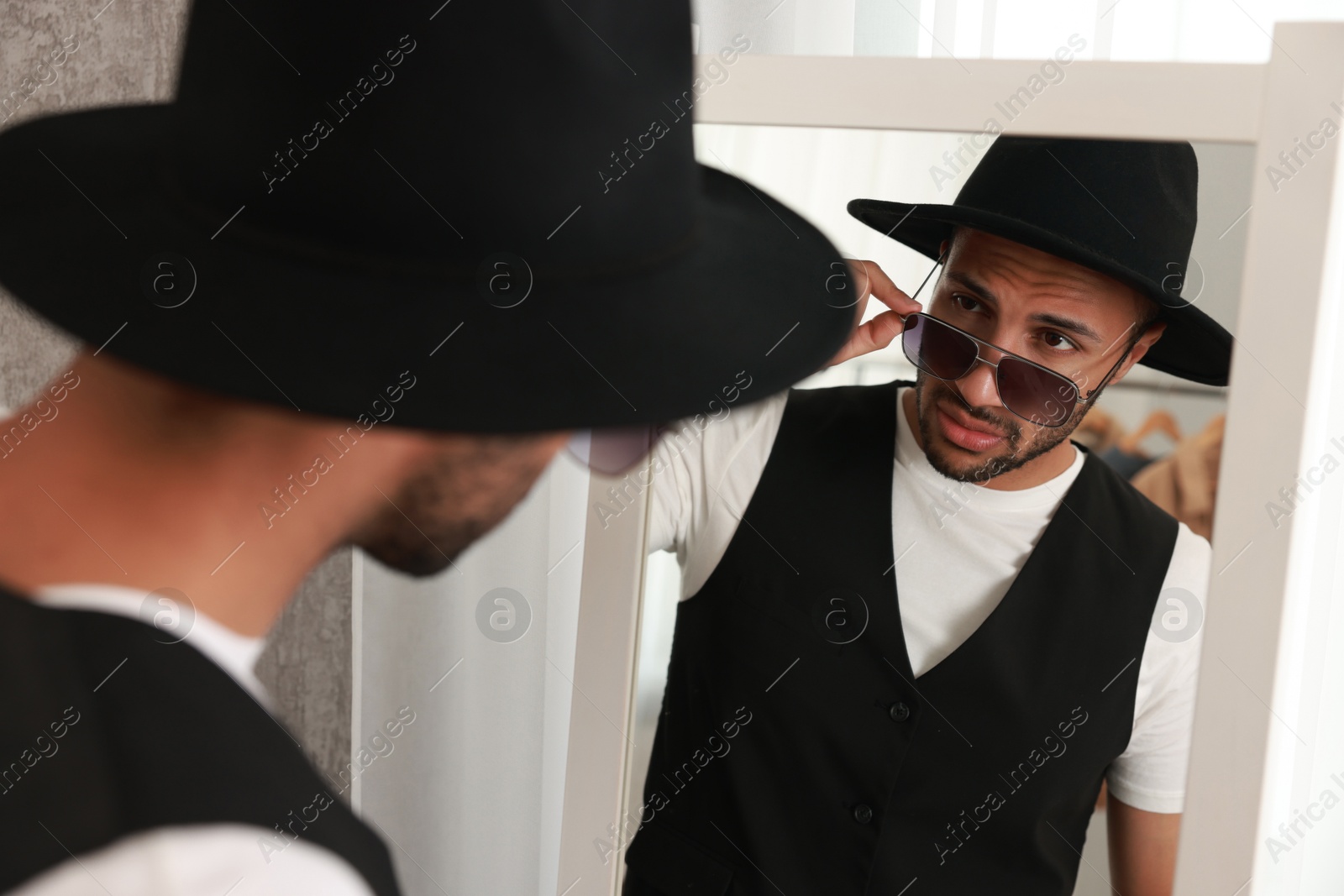 Photo of Handsome man looking at mirror at home