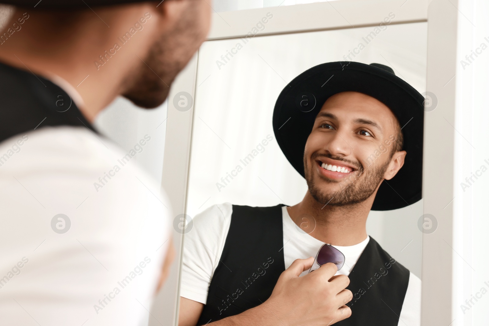 Photo of Smiling man looking at mirror at home