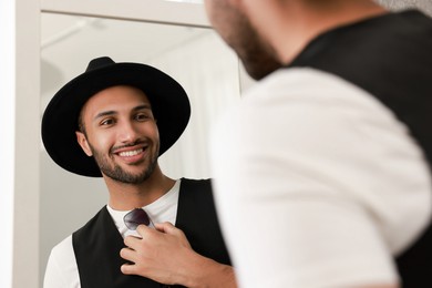 Smiling man looking at mirror at home