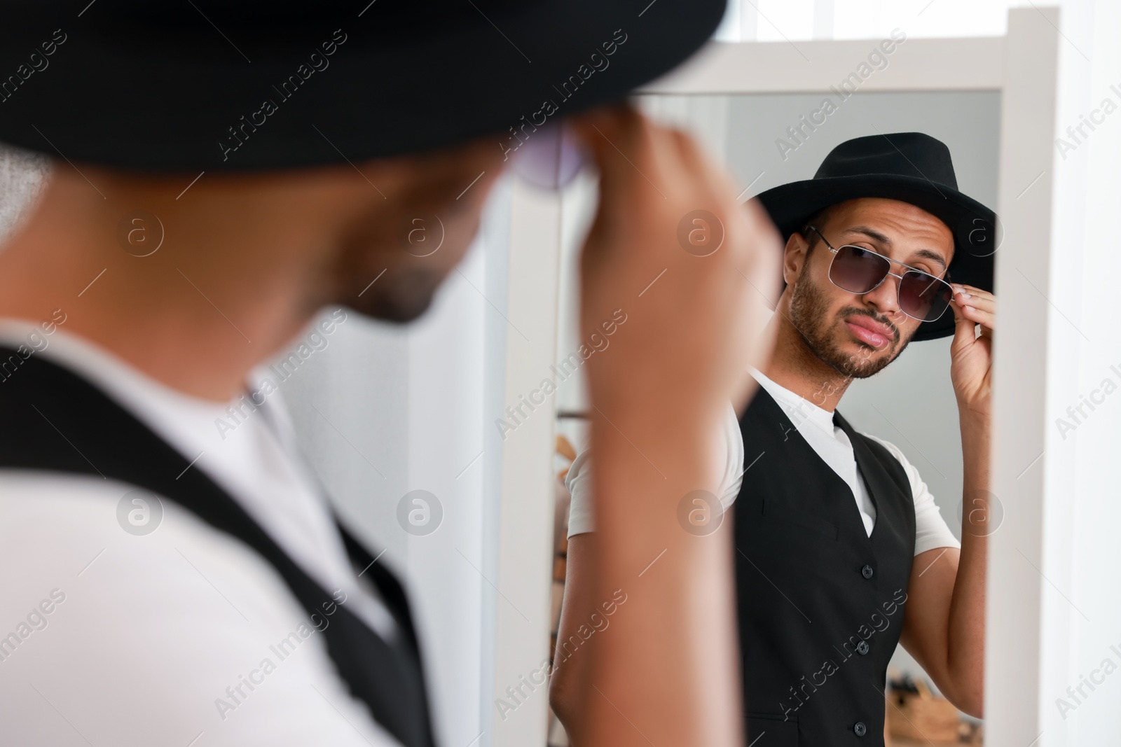 Photo of Handsome man looking at mirror at home