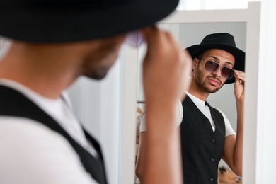 Photo of Handsome man looking at mirror at home