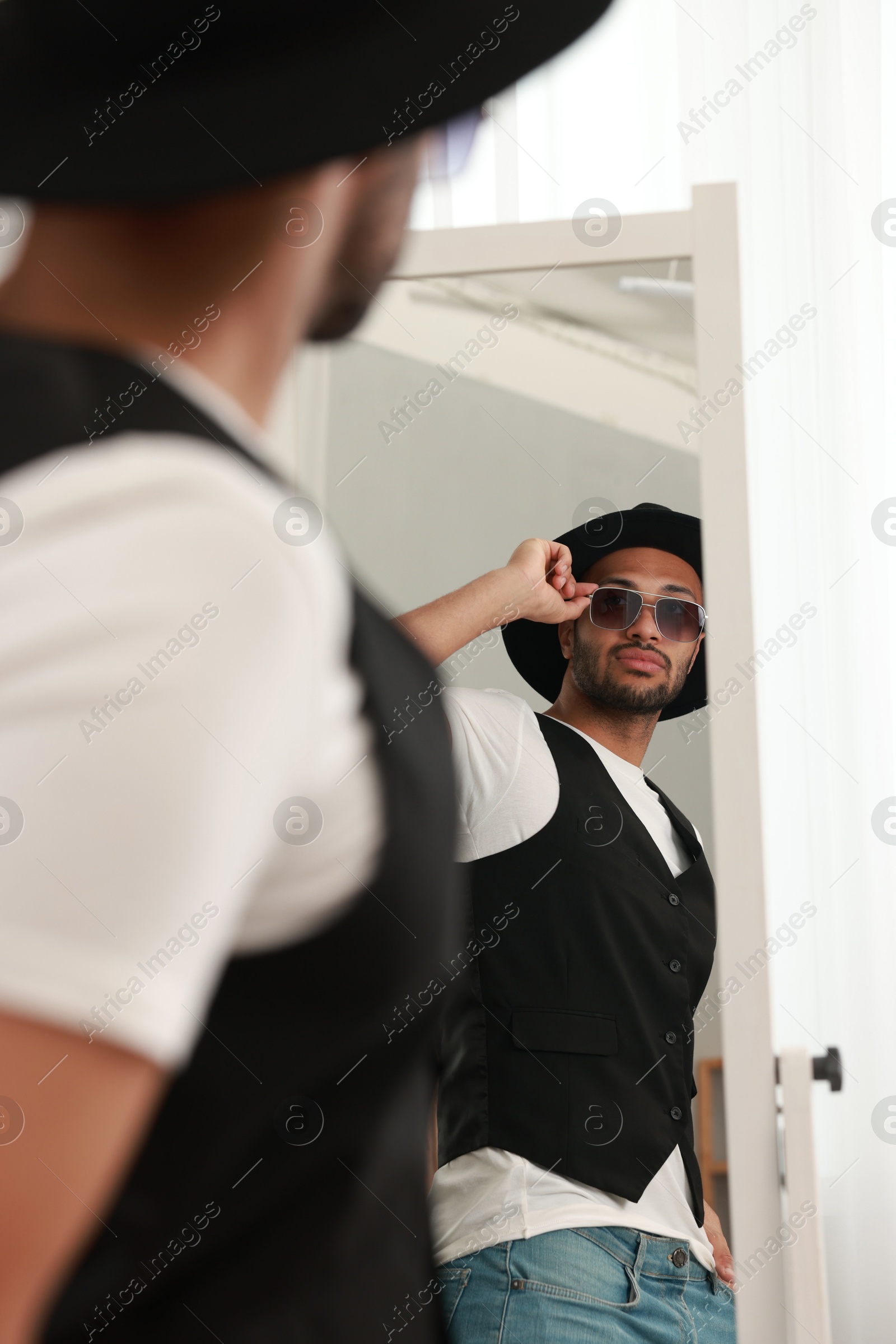 Photo of Handsome man looking at mirror at home