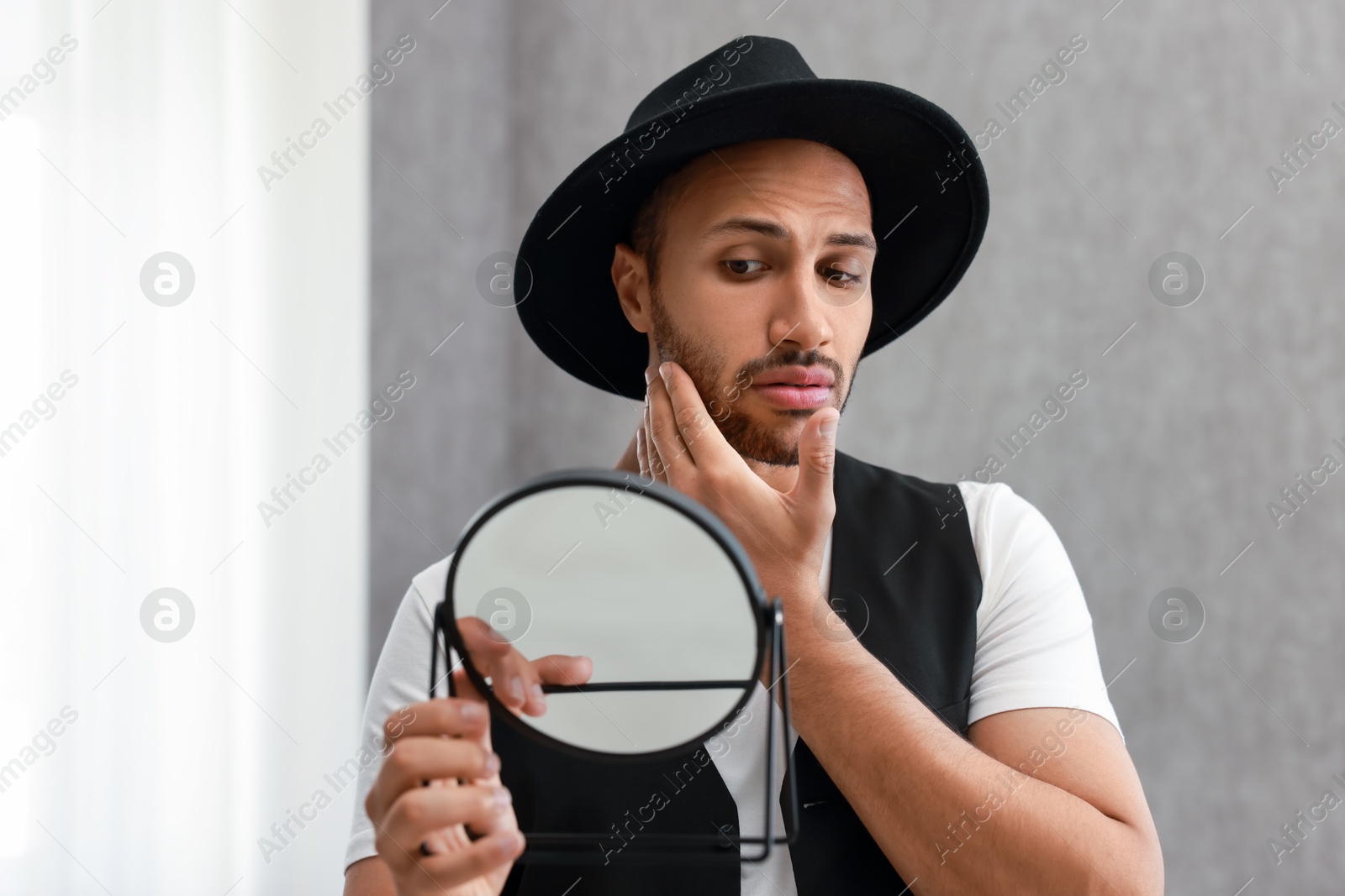 Photo of Handsome man looking at mirror at home