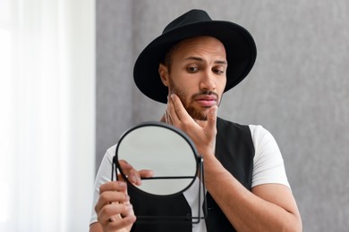 Photo of Handsome man looking at mirror at home