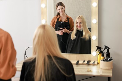 Photo of Hair cutting. Professional hairdresser working with client in salon, selective focus