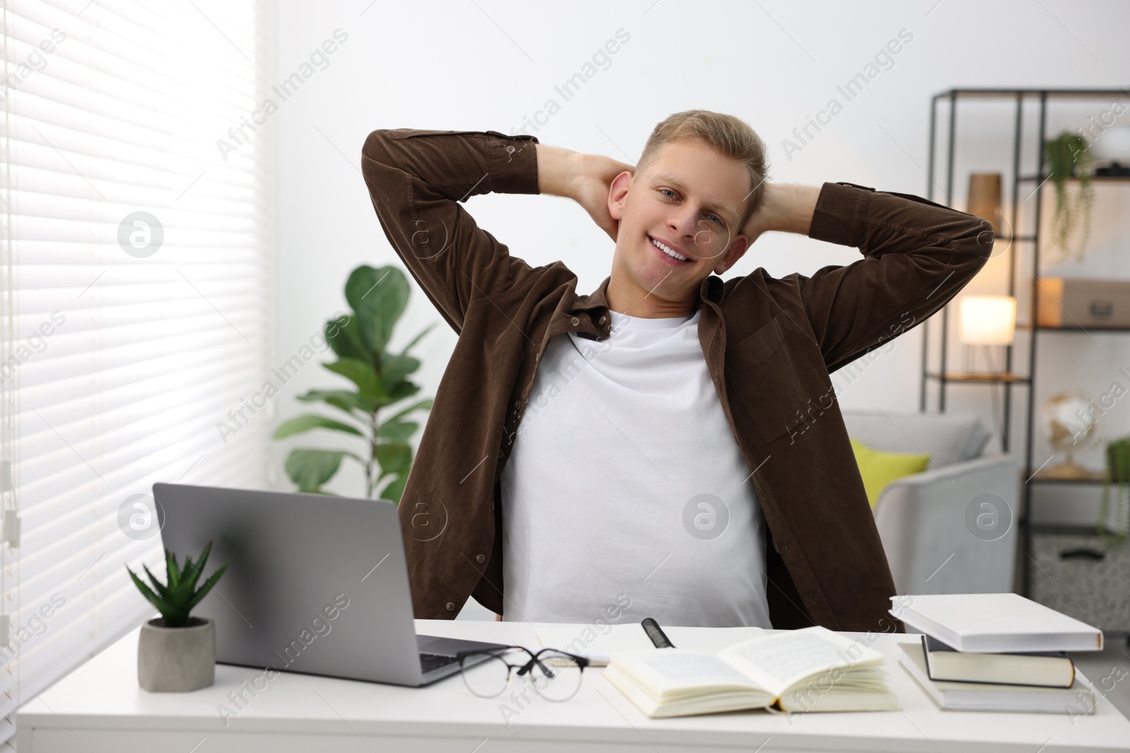 Photo of Preparing for exam. Student with laptop and books at table indoors