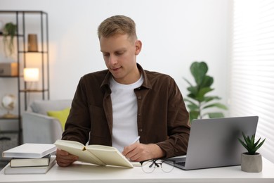 Photo of Student preparing for exam at table indoors