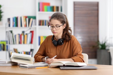 Photo of Student preparing for exam at table indoors