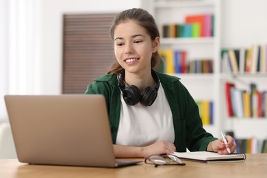 Student preparing for exam with laptop at table indoors