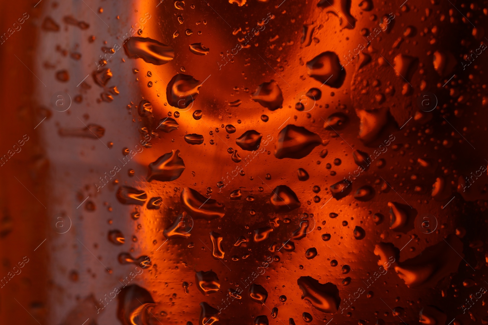 Photo of Water drops on red glass surface, macro view