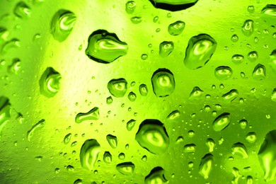 Water drops on green glass surface, macro view