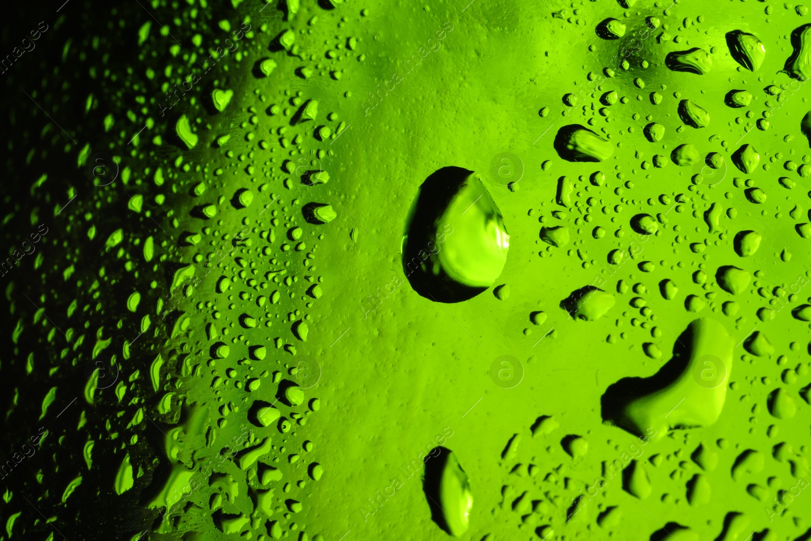 Photo of Water drops on green glass surface, macro view