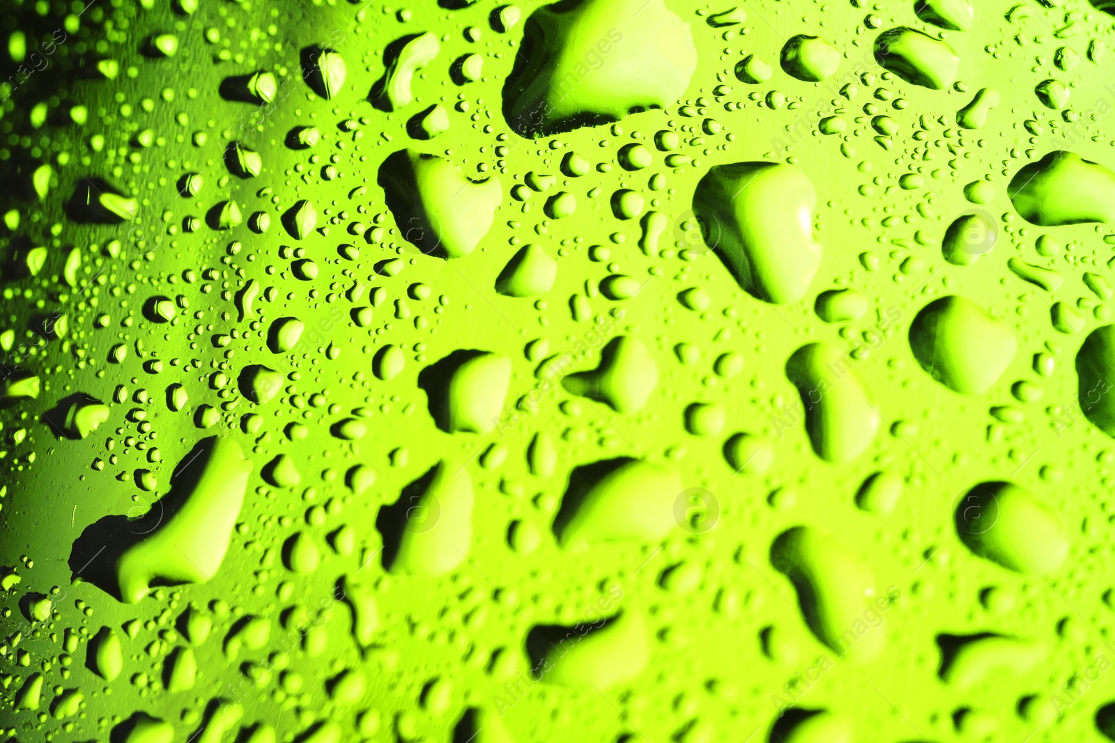 Photo of Water drops on green glass surface, macro view