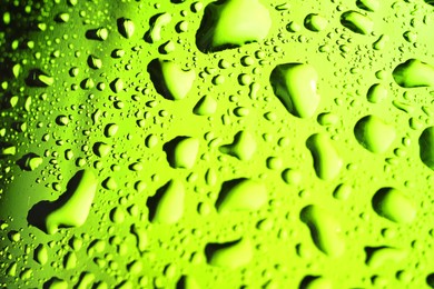 Photo of Water drops on green glass surface, macro view