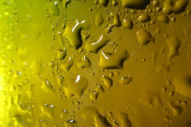 Photo of Water drops on color glass surface, macro view