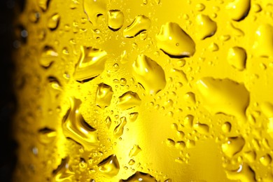 Photo of Water drops on yellow glass surface, macro view