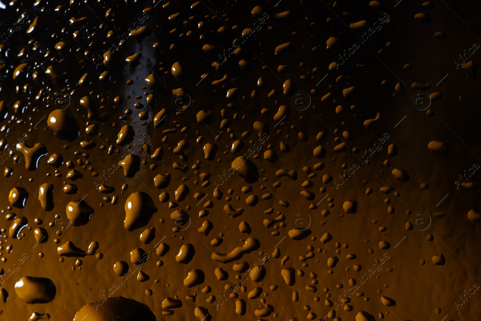 Photo of Water drops on color glass surface, macro view