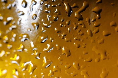 Photo of Water drops on color glass surface, macro view