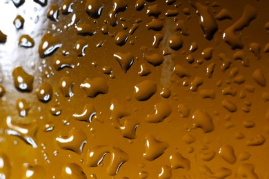 Photo of Water drops on color glass surface, macro view