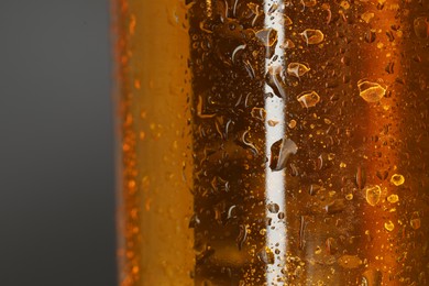 Glass bottle with condensation drops on grey background, macro view