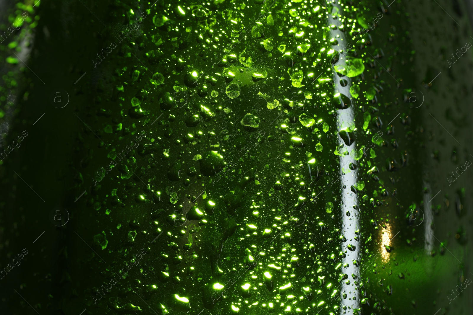 Photo of Glass bottle with condensation drops, macro view