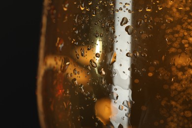 Photo of Glass of beer with condensation drops on black background, macro view