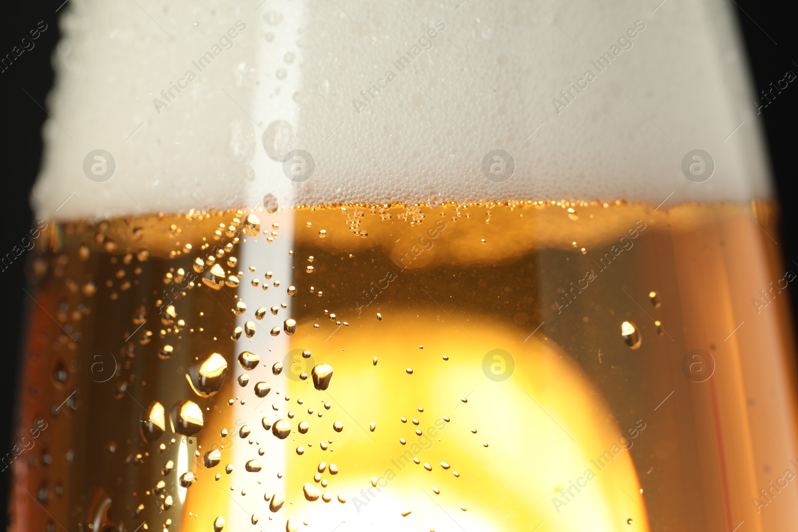 Photo of Glass of beer with condensation drops, macro view