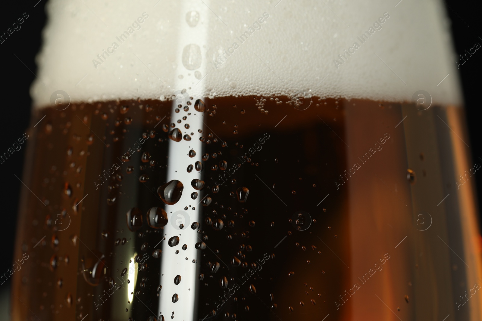 Photo of Glass of beer with condensation drops, macro view