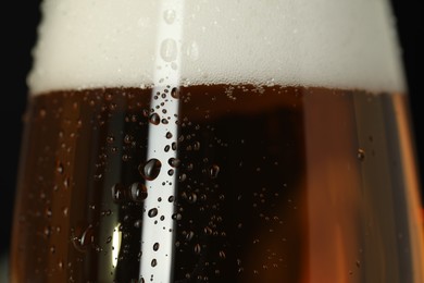 Photo of Glass of beer with condensation drops, macro view