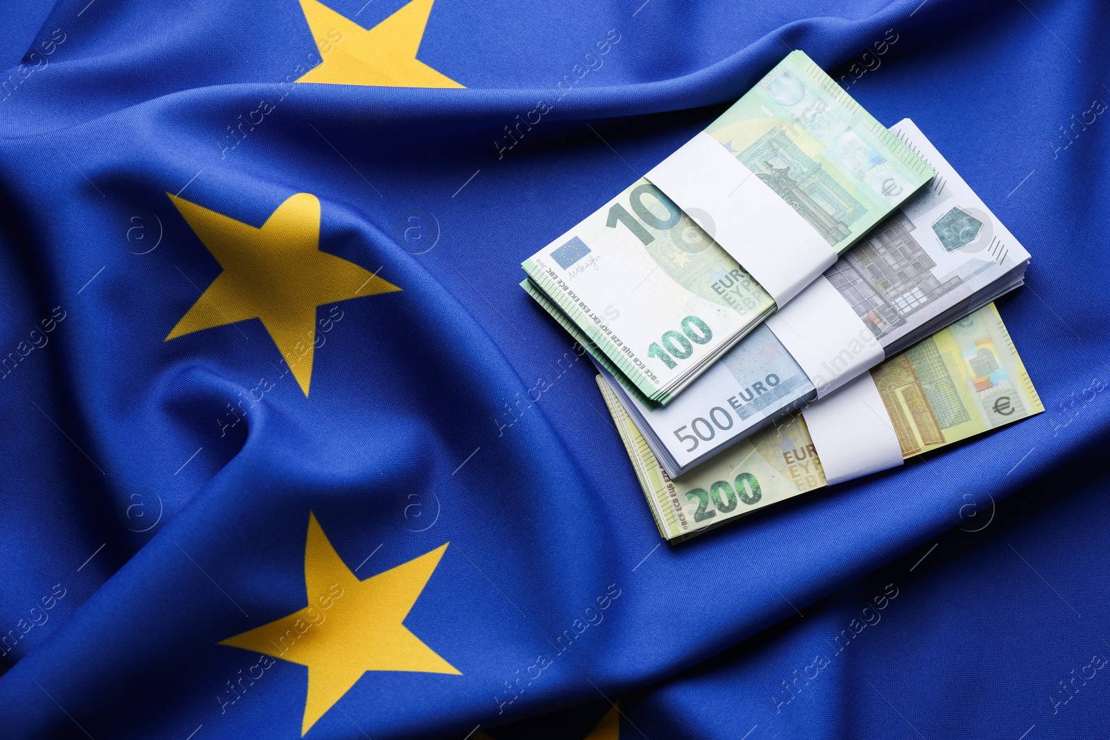 Photo of Euro banknotes on European Union flag, top view