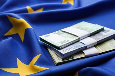 Photo of Euro banknotes on European Union flag, closeup