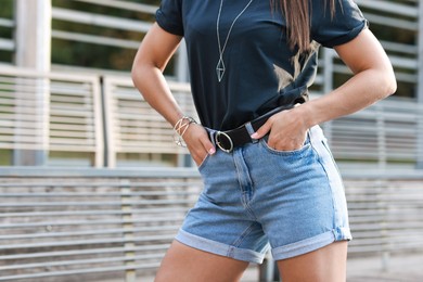 Photo of Woman wearing stylish denim shorts outdoors, closeup