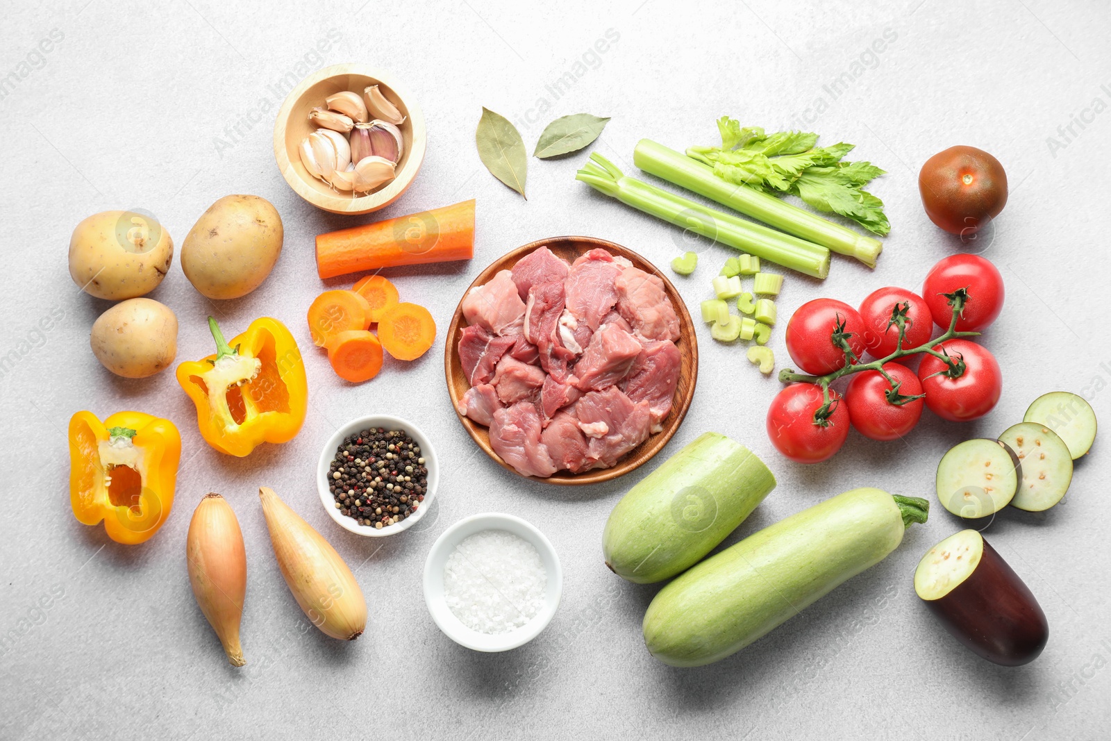 Photo of Cooking stew. Uncooked meat and vegetables on light grey table, flat lay