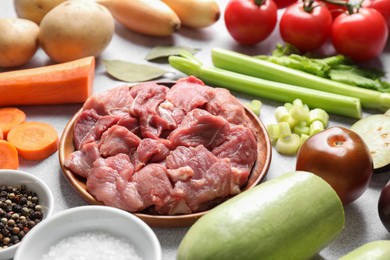 Cooking stew. Uncooked meat and vegetables on light grey table