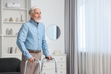 Photo of Senior man using walking frame at home. Space for text