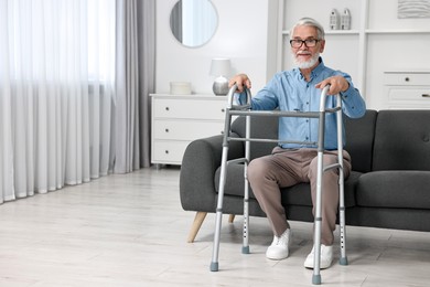 Photo of Senior man with walking frame on sofa at home