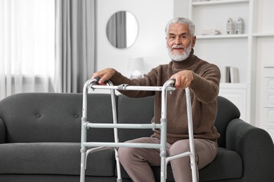 Photo of Senior man with walking frame on sofa at home